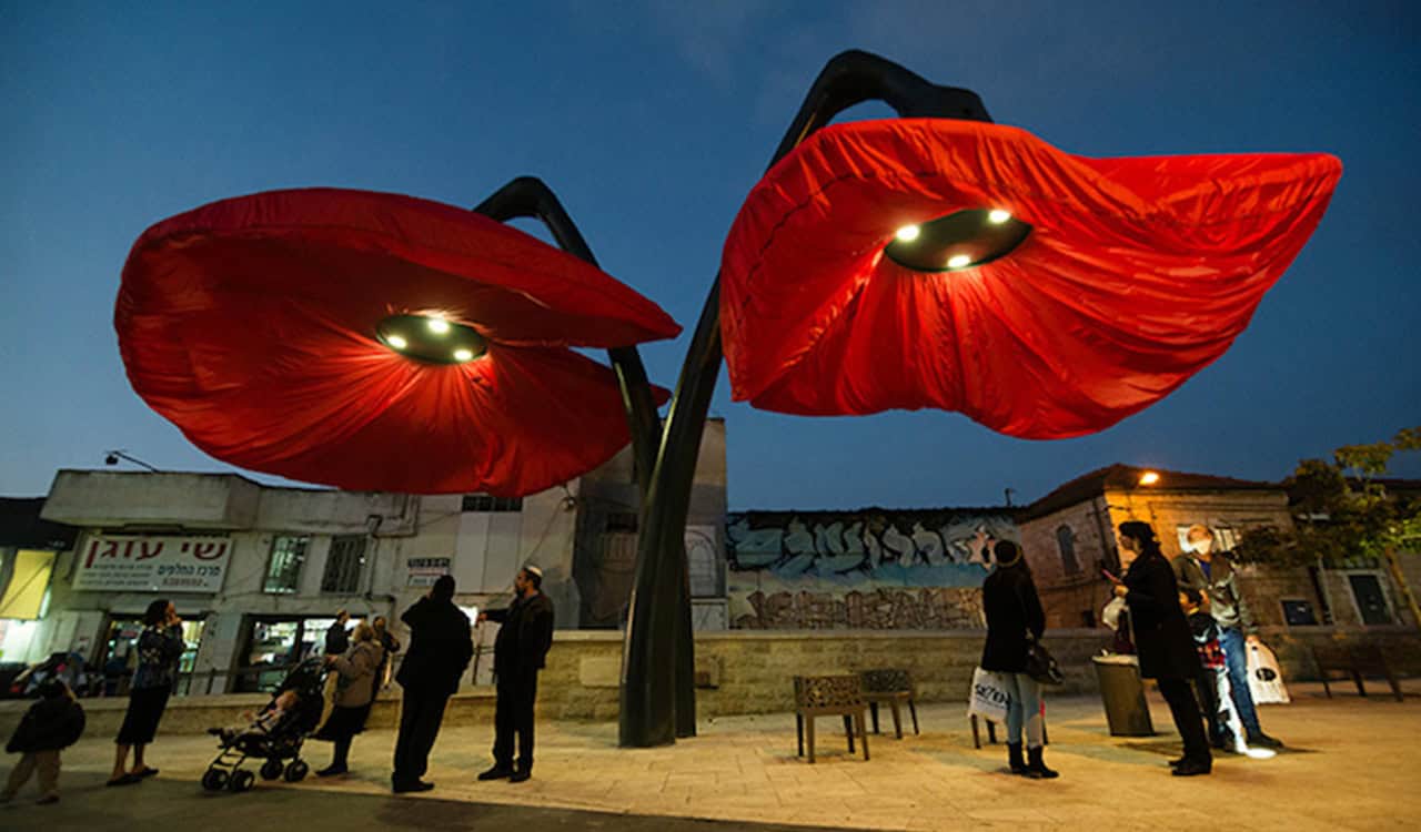 Giant flowers bloom as pedestrians approach